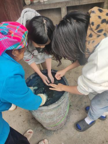 a group of children playing in a bucket of water at Little House in KhauPha, Mu Cang Chai - homestay, cuisine, cafe in Mù Cang Chải