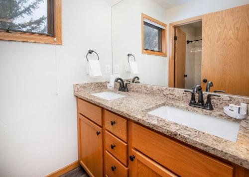 a bathroom with two sinks and a mirror at Greenbrier Townhouse #25 in Avon