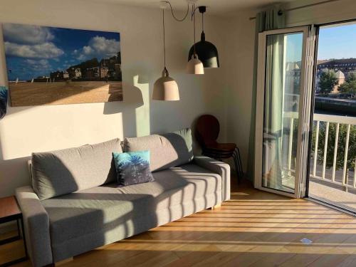 un salon avec un canapé et une grande fenêtre dans l'établissement 40m2, 2 Pieces Hyper Centre Trouville Vue Mer Pour 4 personnes, Arlette Trouville !, à Trouville-sur-Mer