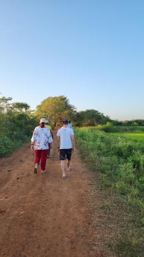 three people walking down a dirt road at Lake10 Eluwankulama in Mulakandaveli