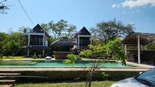 a house with a swimming pool in front of it at Lake10 Eluwankulama in Mulakandaveli