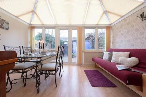 a living room with a table and a couch at 3bedroom Sleeps8 Parking FamilyFriendly NearExcel in London
