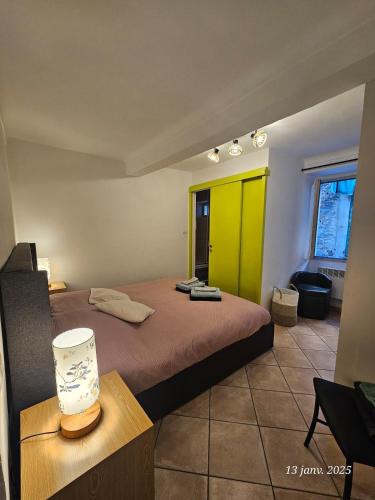 - une chambre avec un lit et une porte jaune dans l'établissement Mignon & Chaleureux village médiéval Castellar Menton, à Castellar