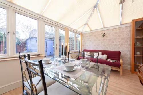 a living room with a glass table and a couch at 3bedroom Sleeps8 Parking FamilyFriendly NearExcel in London