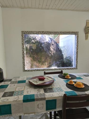 a dining room table with a picture on the wall at Pousada Pitoresca Casa Amarela in Mairiporã