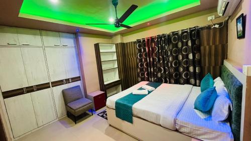 a bedroom with a bed and a green ceiling at Phoenix Nest Homestay in Guwahati