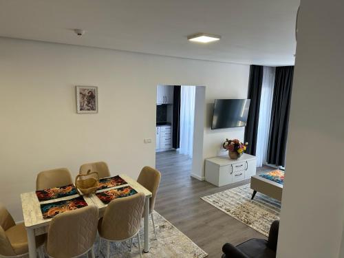 Una sala de estar con una mesa y sillas en una habitación. en Apartament Elizabeth De Luxe Apart Hotel, en Oradea