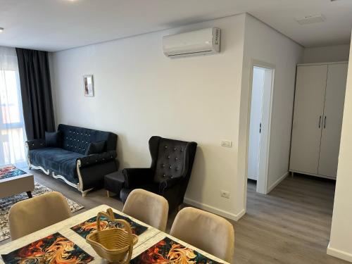 Una sala de estar con un sofá, una mesa y sillas. en Apartament Elizabeth De Luxe Apart Hotel, en Oradea
