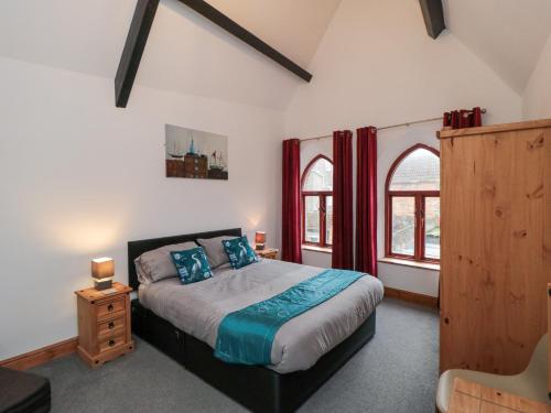 a bedroom with a bed and two windows at Psalm Cottage in Scarborough