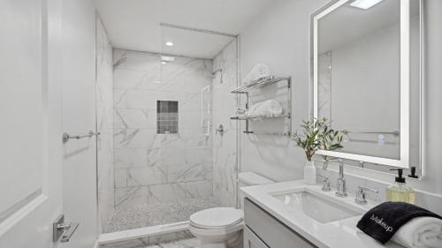 a white bathroom with a shower and a sink at The Eleanor New Orleans in New Orleans