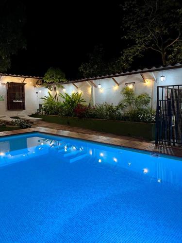 a blue swimming pool at night with lights at Casa hotel Dulce Candelaria in Santa Fe de Antioquia