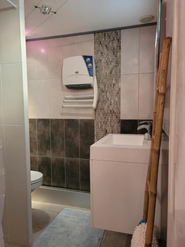 une salle de bain avec des toilettes blanches et un lavabo dans l'établissement Maisonnette vue mer zone naturiste, à Leucate-Plage