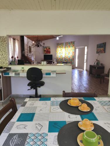 a dining room with a table with plates on it at Pousada Pitoresca Casa Amarela in Mairiporã