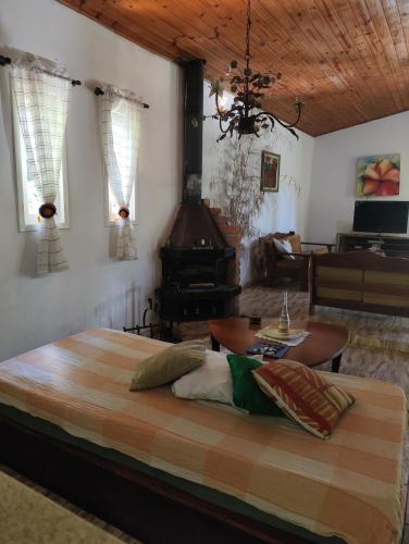 a bedroom with a bed and a living room at Pousada Pitoresca Casa Amarela in Mairiporã