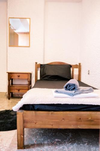 a bedroom with a wooden bed with a mirror at LaPlayaSuites 1st in Periyiálion