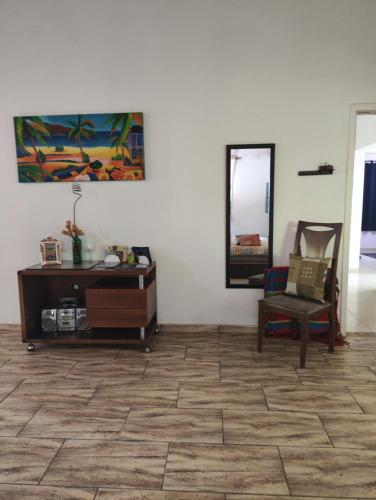 a room with a table and a chair and a mirror at Pousada Pitoresca Casa Amarela in Mairiporã