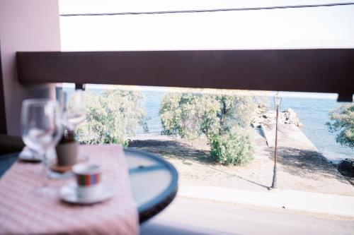 a table with wine glasses and a view of the ocean at LaPlayaSuites 1st in Periyiálion