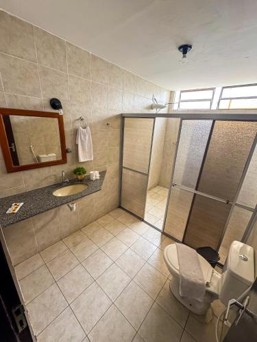 a bathroom with a shower and a sink and a toilet at Hotel Pousada Do Lago in Campo Maior