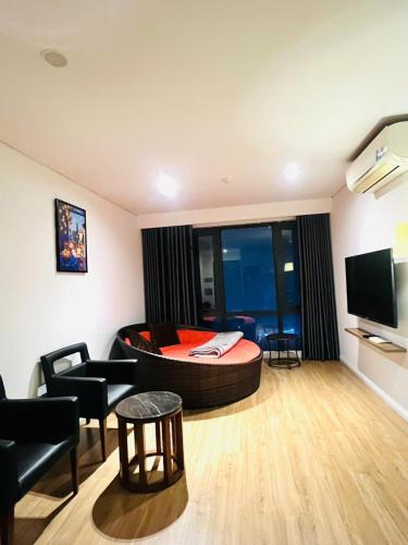 a living room with a large bed and a television at Emoi Mipec Riverside's Apt in Hanoi