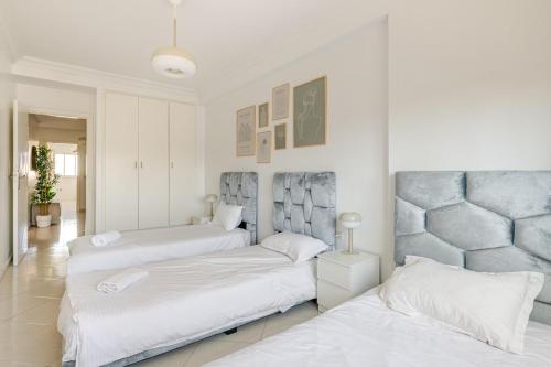 two beds in a room with white walls at Rabat Centro Apartments in Rabat