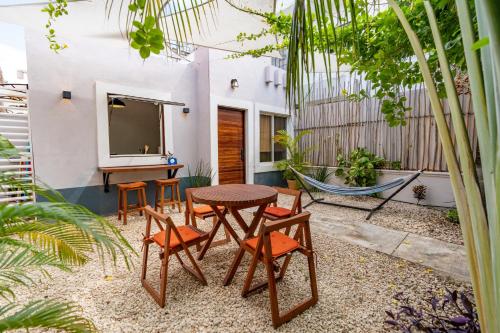 a patio with a table and chairs and a table at Colorful Downtown House with Private Pool in Tulum