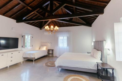 a bedroom with two beds and a flat screen tv at Senhora do Carmo Charm House in Ponta Delgada
