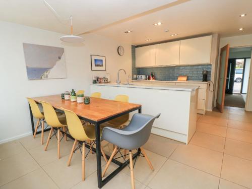 a kitchen and dining room with a wooden table and chairs at 6 Inveravon in Christchurch