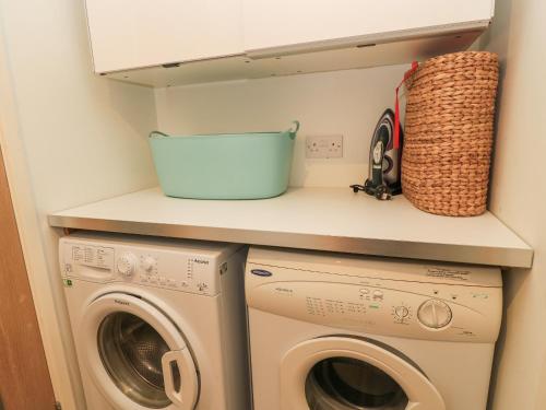 a small laundry room with a washer and dryer at 6 Inveravon in Christchurch