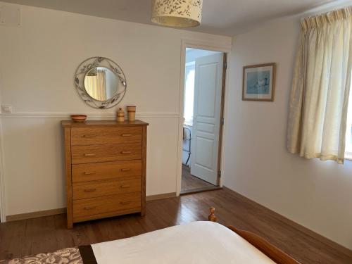 a bedroom with a dresser and a mirror on the wall at Chez Casa in Sourdeval