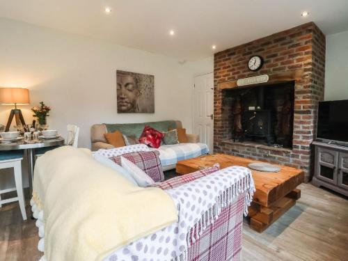 ein Wohnzimmer mit Couch und Kamin in der Unterkunft Ellesmere Cottage in Hornsea