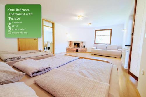 a room with three beds and a couch in it at Small wooden houses and Apartments Zgornja Dobrava in Radovljica