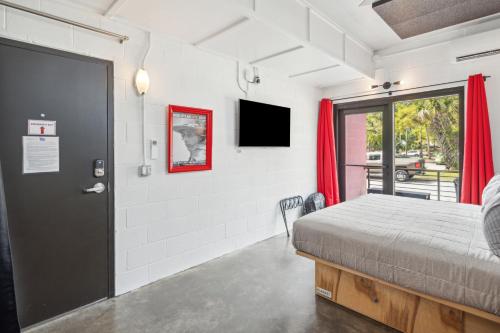 a bedroom with a bed and a door with a window at Boutique Vera Hotel in the Heart of Folly Beach in Folly Beach