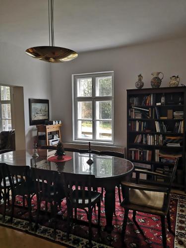 a dining room with a table and chairs and a book shelf at Kronichhof in Knappenberg