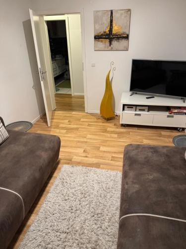 a living room with a couch and a flat screen tv at Fewo Zum Wohlfühlen in Hemmoor