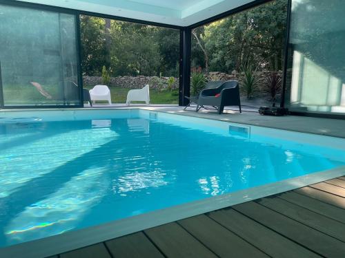 ein Swimmingpool mit zwei Stühlen und ein Swimmingpool in der Unterkunft La Grande Parenthèse Villa Golfe du Morbihan in Larmor-Baden