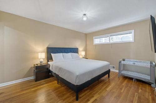 a bedroom with a large bed and a window at Perfect Group Stay 7 Beds Sleeps 15 Massage Chair 20 Min NYC in Bayonne