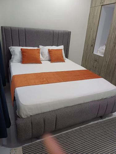 a bedroom with a large bed with orange pillows at Es Su Casa in Mombasa