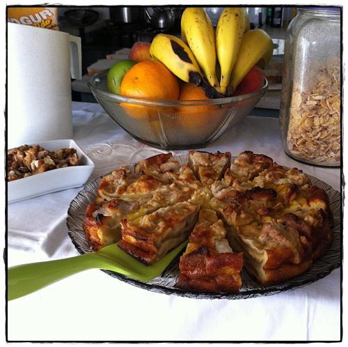 una torta su un piatto accanto a una ciotola di frutta di La Pedrasanta a La Pedrera