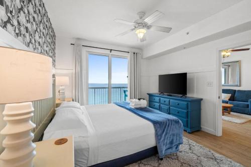 una camera con un letto, un comò blu e una TV di Seychelles Unit 1205 a Panama City Beach
