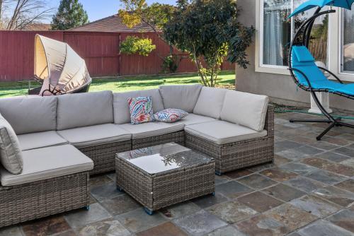 a couch and chairs on a patio with an umbrella at Game Lovers Retreat, spacious 4000 sqft Getaway in El Dorado Hills