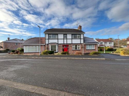 a house with a red door on a street at Portora House Accommodation ROOM ONLY-ALL ROOMS EN-SUITE in Enniskillen