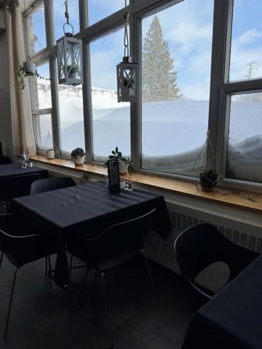 a room with tables and chairs and a window with a view at Manoir d'Youville in Châteauguay Heights