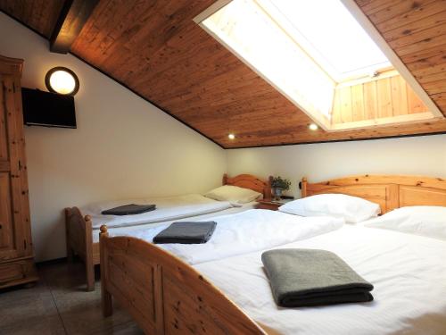 a attic bedroom with two beds and a skylight at Elizabeth Łeba - Pokoje Gościnne in Łeba