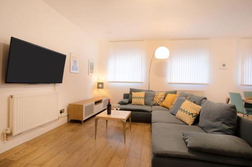 a living room with a couch and a flat screen tv at 3BR, smart TV, self check-in, coffee machine in Manchester