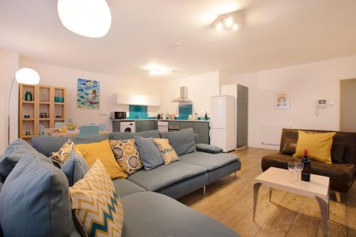 a living room with a blue couch and a kitchen at 3BR, smart TV, self check-in, coffee machine in Manchester