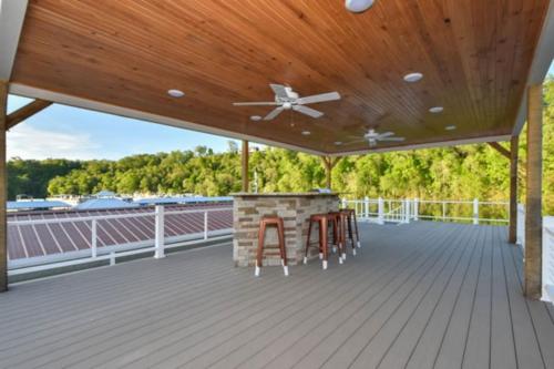 a deck with a wooden ceiling and a bar with stools at Cream Houseboat 4 Bedroom in Nancy