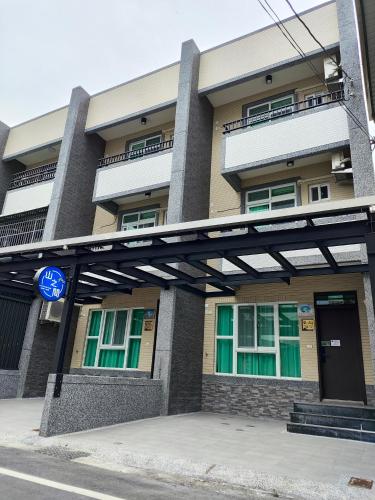 a building with a blue sign in front of it at 山之間特色民宿 自助入住 包棟附電動麻將 in Yuli
