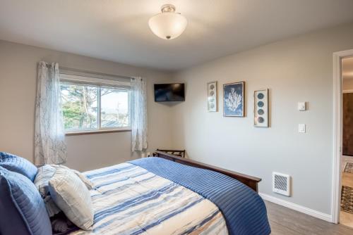 a bedroom with a bed and a window at Pacific Peek One - OceanView - EV Charger - Pet OK in Wecoma Beach