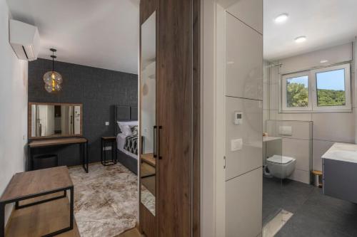 un baño con inodoro y lavabo en Villa with 6 Bedrooms and Heated Pool, en Mošćenička Draga