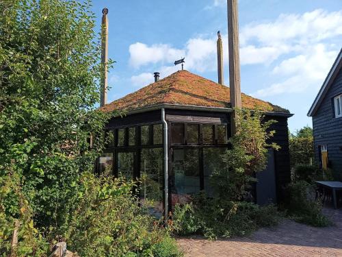 an old building with a roof with a roof at Ons Huisje Achter - De Hooischuur in Noordwijkerhout